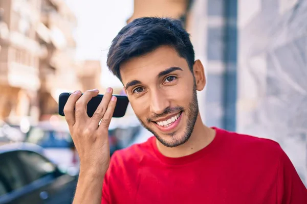 Jovem Latino Sorrindo Feliz Ouvir Mensagem Áudio Usando Smartphone Cidade — Fotografia de Stock