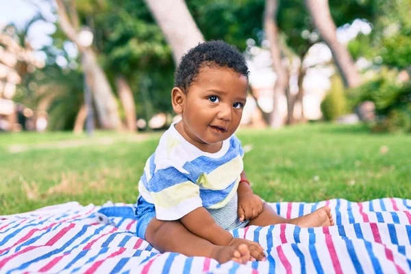 可敬的非洲裔美国胖乎乎的幼儿坐在公园的草地上 — 图库照片