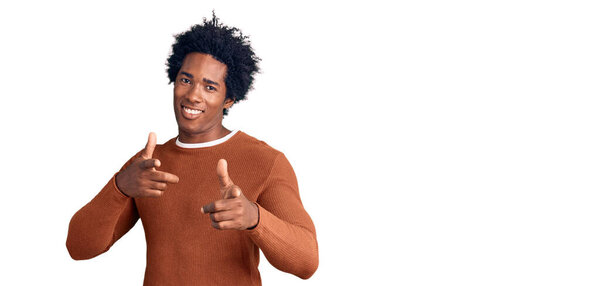 Handsome african american man with afro hair wearing casual clothes pointing fingers to camera with happy and funny face. good energy and vibes.