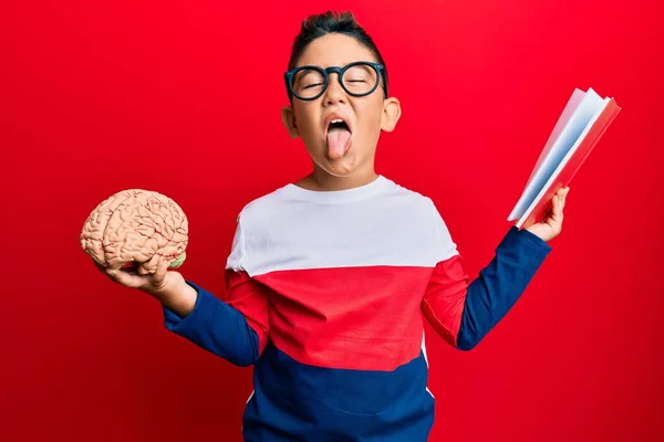 小さな男の子Hispanic子供保持脳研究のために学校ステッキング舌アウト幸せとともに面白い式 — ストック写真