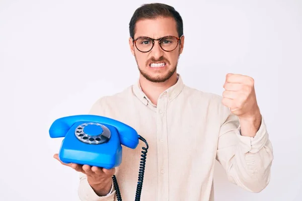 Mladý Pohledný Muž Drží Starý Telefon Otrávený Frustrovaný Křičí Hněvem — Stock fotografie