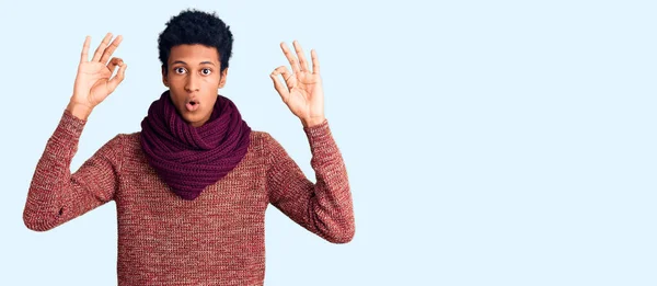 カジュアルな冬のセーターとスカーフを身に着けている若いアフリカ系アメリカ人の男性は驚きと指でOk承認シンボルをやってショックを受けました クレイジーな表現 — ストック写真