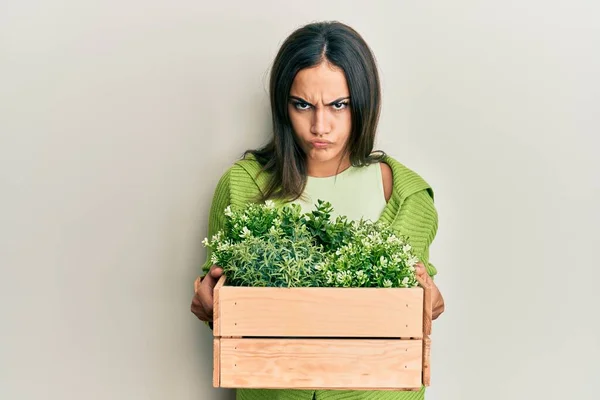 Young Brunette Woman Holding Wooden Plant Pot Skeptic Nervous Frowning — Stock Photo, Image