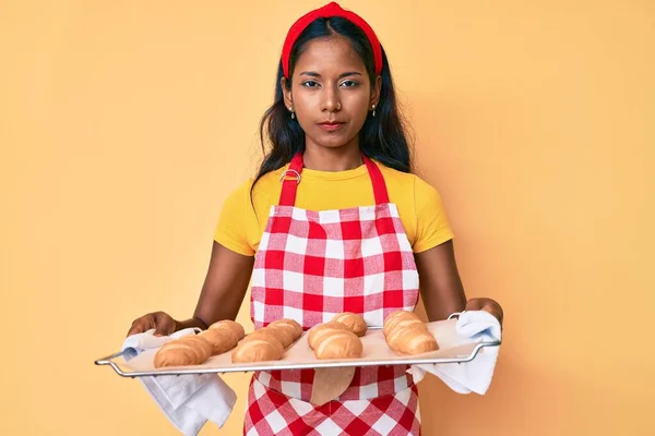Młoda Hinduska Dziewczyna Mundurze Piekarza Trzymająca Domowej Roboty Chleb Sceptyczny — Zdjęcie stockowe