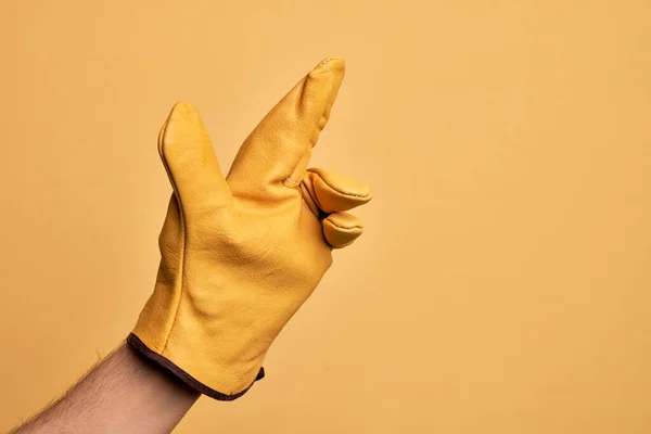 Mão Homem Jovem Caucasiano Com Luva Jardineiro Sobre Fundo Amarelo — Fotografia de Stock