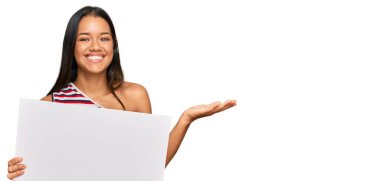 Güzel İspanyol kadın boş afiş tutuyor zaferi mutlu bir gülümsemeyle ve kazanan yüz ifadesiyle kutluyor. 