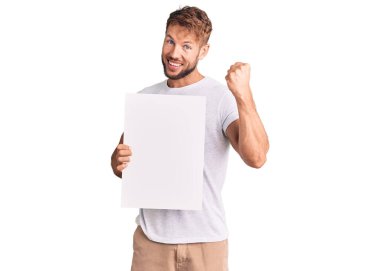 Kafkasyalı genç adam boş bir pankart tutuyor gururla bağırıyor, zaferi kutluyor ve kollarını kaldırarak çok heyecanlanıyor. 