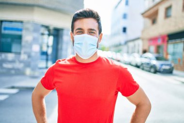 Kentin caddesinde duran yakışıklı İspanyol koruma maskesi takan yakışıklı adam..