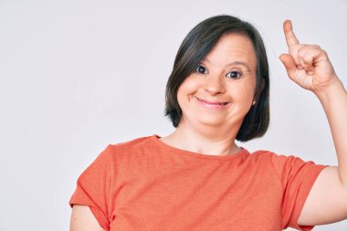 Down sendromlu esmer kadın gündelik kıyafetler giyip başarılı bir fikri işaret ediyor. Heyecanlı ve mutlu. Bir numara.. 