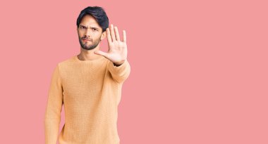 Avuç içiyle şarkı söylemeyi kesen, günlük süveter giyen yakışıklı İspanyol. Yüzünde olumsuz ve ciddi bir jest olan uyarı ifadesi. 