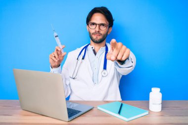 Klinikteki yakışıklı İspanyol doktor elinde şırıngayla kamerayı ve seni işaret ediyor. Kendine güveni tam bir jest. 