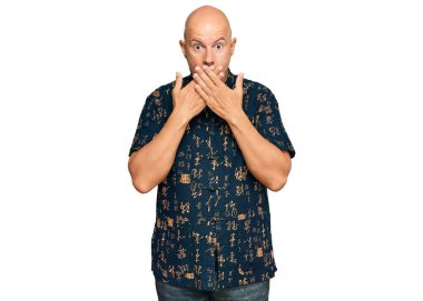 Sıradan kıyafetler giyen orta yaşlı kel bir adam yanlışlıkla elleri ile ağzını kapatırken şok oldu. gizli kavram. 