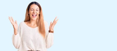 Başarılı olmak için çılgınca ve çılgınca kutlamalar yapan gündelik kıyafetler giyen güzel genç bir kadın. Kollarını kaldırmış, gözlerini kapatmış heyecanlı çığlıklar atıyordu. Kazanan konsept 