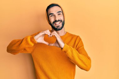 Sakallı, süveter giyen, yün şapkalı, kuşkuya odaklanmış, çenesinde parmak olan genç bir İspanyol. 