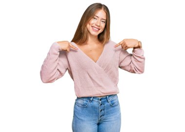 Güzel sarışın kadın, günlük pembe süveter giyiyor. Kendine güvenen, gülümseyen, kendini gururlu ve mutlu gösteren.. 