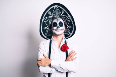 Ölü kostümü giymiş bir adam kollarını kavuşturup kameraya bakarken gülümseyen beyaz mutlu yüzün üzerine. pozitif kişi. 