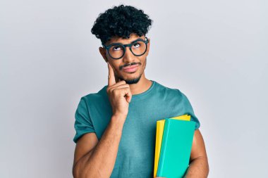 Gözlük takan, kitap tutan, ciddi yüzlü, eli çenesinde soru soran, kafası karışık, düşünceli genç bir Arap. 