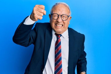 Beyaz üst düzey bir adam iş elbisesi giyiyor ve kravat takıyor kızgın ve kızgın yumruğunu kaldırıyor ve öfkeyle bağırıyor. öfke ve agresif konsept. 