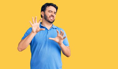 Gündelik kıyafetler giyen genç İspanyol adam tiksinti ifadesi takındı, tiksinti tepkisi yüzünden tiksinti ve korku dolu bir ifade takınıyordu. Eller havada. 