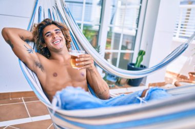 Genç İspanyol adam terasta hamakta uzanmış bira içerek rahatladı..