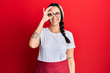 Profesyonel garson önlüğü giyen genç İspanyol kadın başarı için çıldırıyor ve çıldırıyor kollarını kaldırıyor ve gözleri kapalı heyecanla bağırıyor. Kazanan konsept 