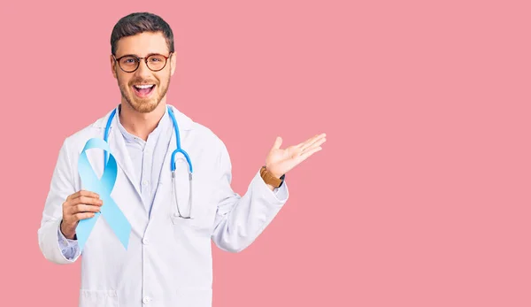 Jovem Bonito Com Urso Vestindo Uniforme Médico Segurando Fita Azul — Fotografia de Stock