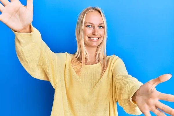 Mladá Blondýnka Neformálním Oblečení Dívá Kameru Usmívá Otevřenou Náručí Aby — Stock fotografie