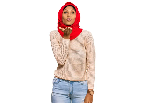 伝統的なイスラム教のヒジャーブスカーフを身に着けている若いアフリカ系アメリカ人女性は カメラを見て 空気中の美しいとセクシーさに手でキスを吹いています 愛の表現 — ストック写真