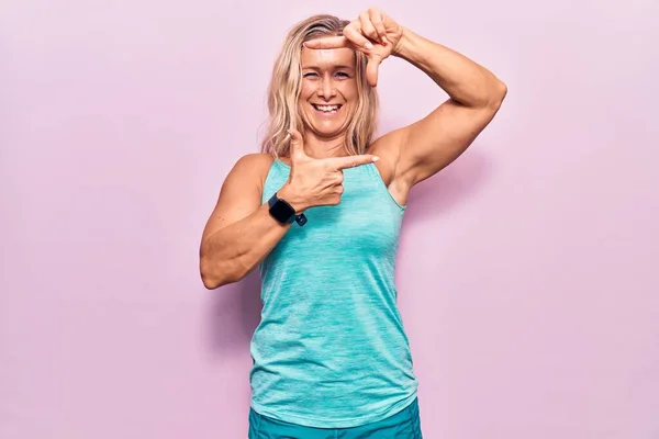 Middelbare Leeftijd Kaukasische Blonde Vrouw Dragen Sportkleding Roze Achtergrond Glimlachen — Stockfoto