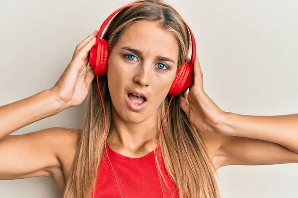 Mujer Rubia Joven Escuchando Música Usando Auriculares Cara Choque Mirando —  Fotos de Stock