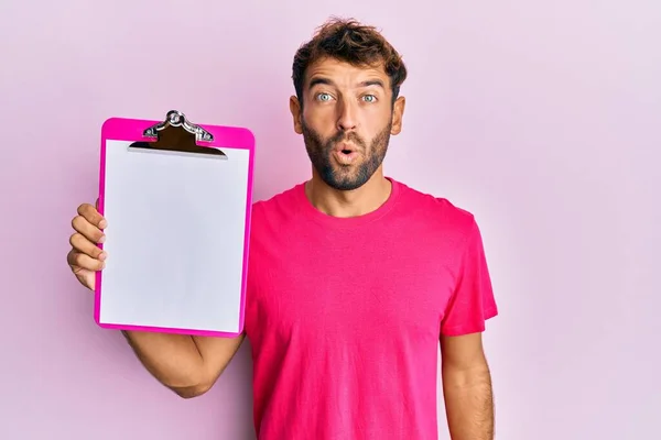 Handsome Man Beard Holding Clipboard Showing Blank Space Scared Amazed — Stock Photo, Image