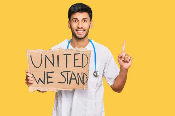 Young Handsome Man Wearing Doctor Uniform Holding United Stand Banner — Stock Photo, Image