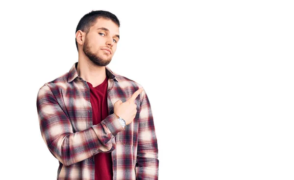 Młody Przystojny Mężczyzna Ubrany Luźną Koszulę Wskazujący Palcem Bok Reklamę — Zdjęcie stockowe