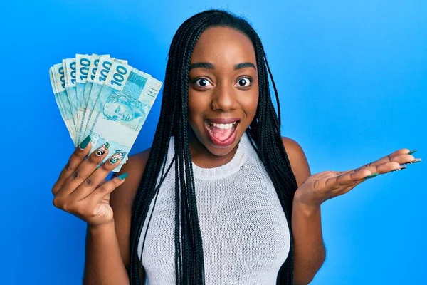 Joven Mujer Afroamericana Sosteniendo 100 Billetes Reales Brasileños Celebrando Logro — Foto de Stock