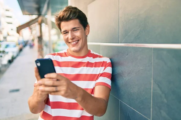 Joven Hombre Caucásico Sonriendo Feliz Usando Teléfono Inteligente Ciudad —  Fotos de Stock
