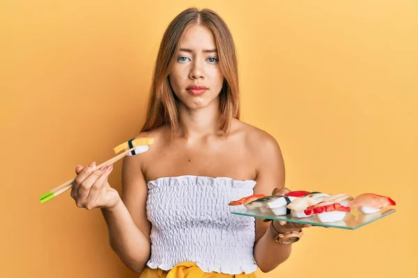 Beautiful Young Blonde Woman Eating Omelette Sushi Using Chopsticks Relaxed — Stock Photo, Image