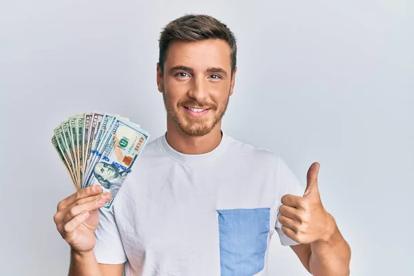 Hombre Caucásico Guapo Sosteniendo Dólares Sonriendo Feliz Positivo Pulgar Hacia —  Fotos de Stock