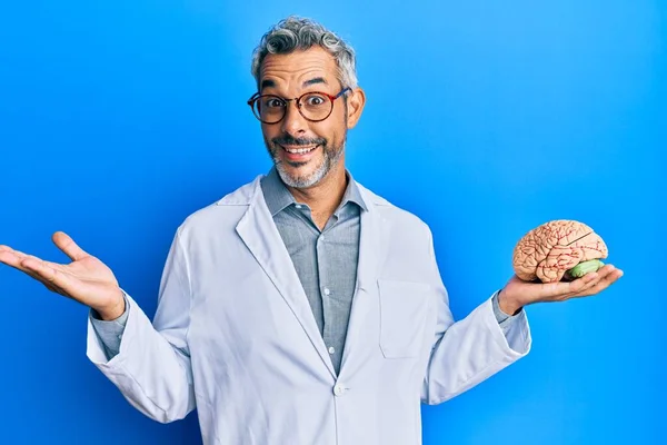 Homem Cabelos Grisalhos Meia Idade Usando Casaco Médico Segurando Cérebro — Fotografia de Stock