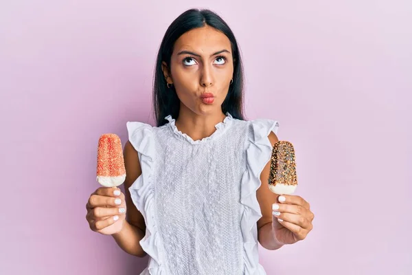 若いですブルネットArab女性を保持していますアイスクリーム作り魚の顔とともに口と目を細めて クレイジーとコミカル — ストック写真
