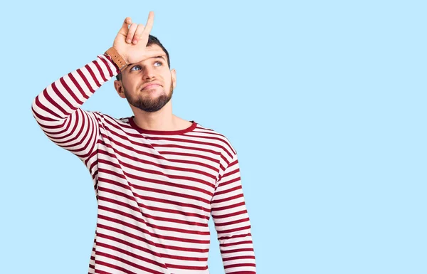 Jovem Homem Bonito Vestindo Camisola Listrada Zombando Pessoas Com Dedos — Fotografia de Stock