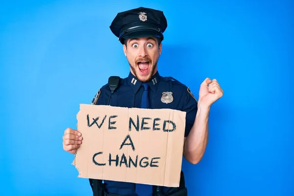 Młody Biały Mężczyzna Mundurze Policyjnym Trzymający Się Potrzebujemy Zmiany Transparentu — Zdjęcie stockowe
