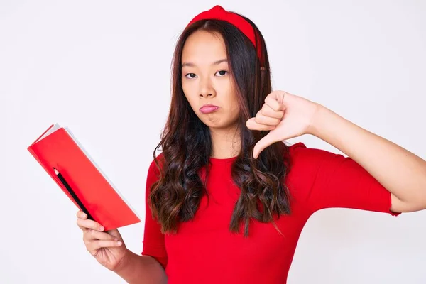 Giovane Bella Ragazza Cinese Possesso Libro Con Faccia Arrabbiata Segno — Foto Stock