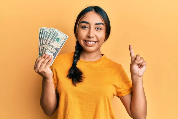 Young Latin Woman Holding Dollars Smiling Idea Question Pointing Finger — Stock Photo, Image