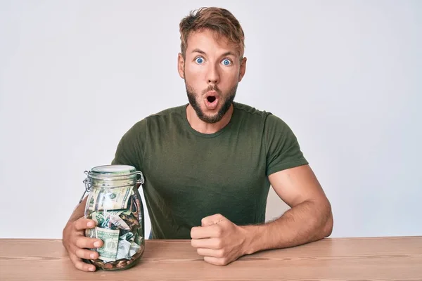 Jonge Blanke Man Die Een Pot Met Spaargeld Tafel Vasthoudt — Stockfoto