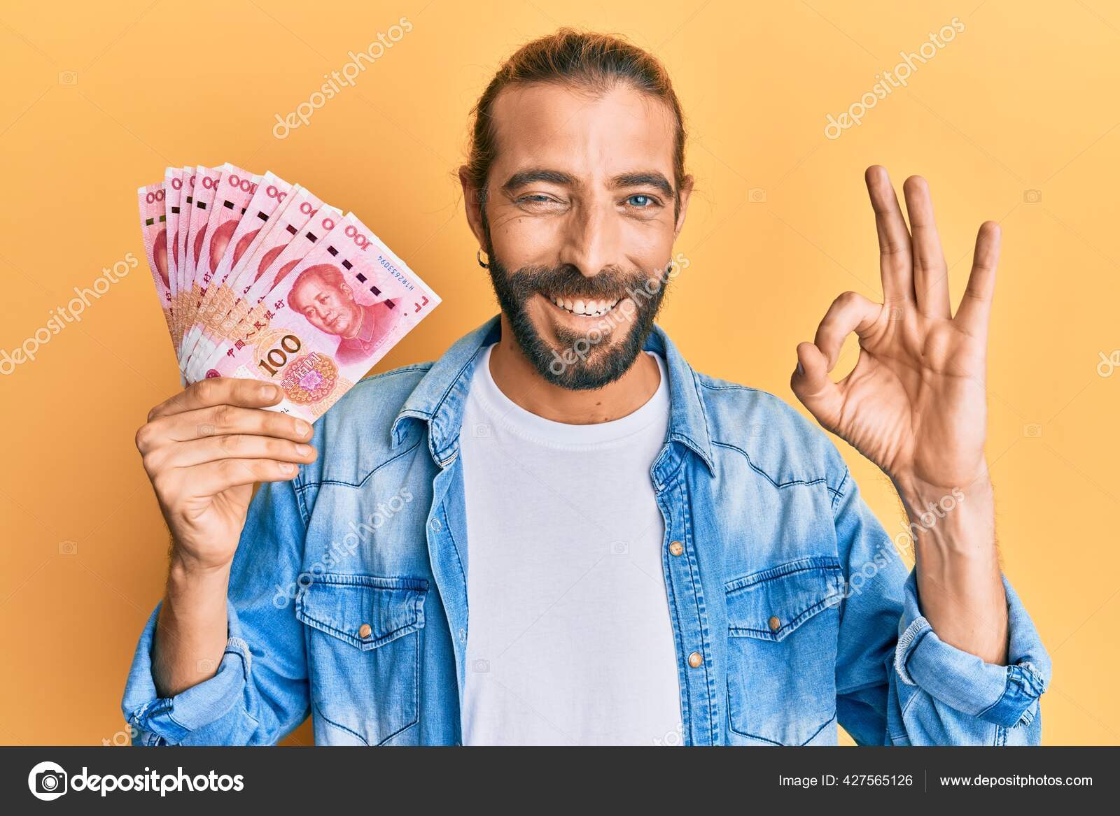 有魅力的长发大胡子的男人手握100元人民币的钞票手握手握手签微笑友善的手势象征着极好的象征——图库图片© Krakenimages.com #