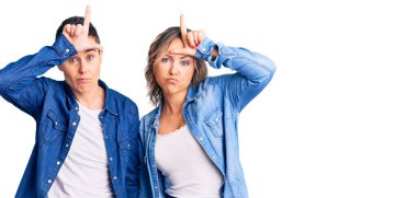 Sıradan kıyafetler giyen, alnında parmakları olan insanlarla dalga geçen ezik hareketler yapan, alay eden iki kadın.. 