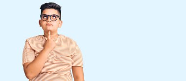 Günlük giysiler ve gözlük takan küçük bir çocuk şüphe üzerine yoğunlaşmıştı. Parmakları çenesinde ve yukarı bakıyordu. 