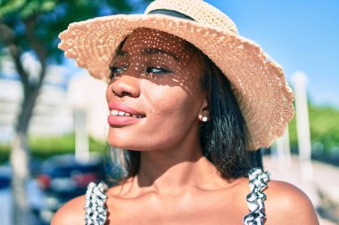 Genç Afro-Amerikan kadın tatilde gülümsüyor ve şehrin sokaklarında mutlu bir şekilde yürüyor.