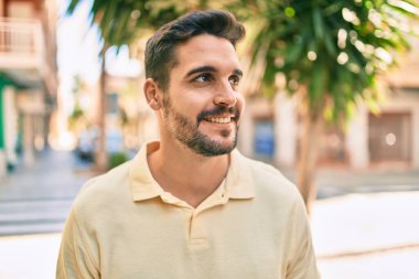 Genç İspanyol adam gülümseyerek şehirde mutlu bir şekilde yürüyor..