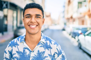 Yaz tarzı giyinen genç Arap turist şehrin caddesinde yürüyor..